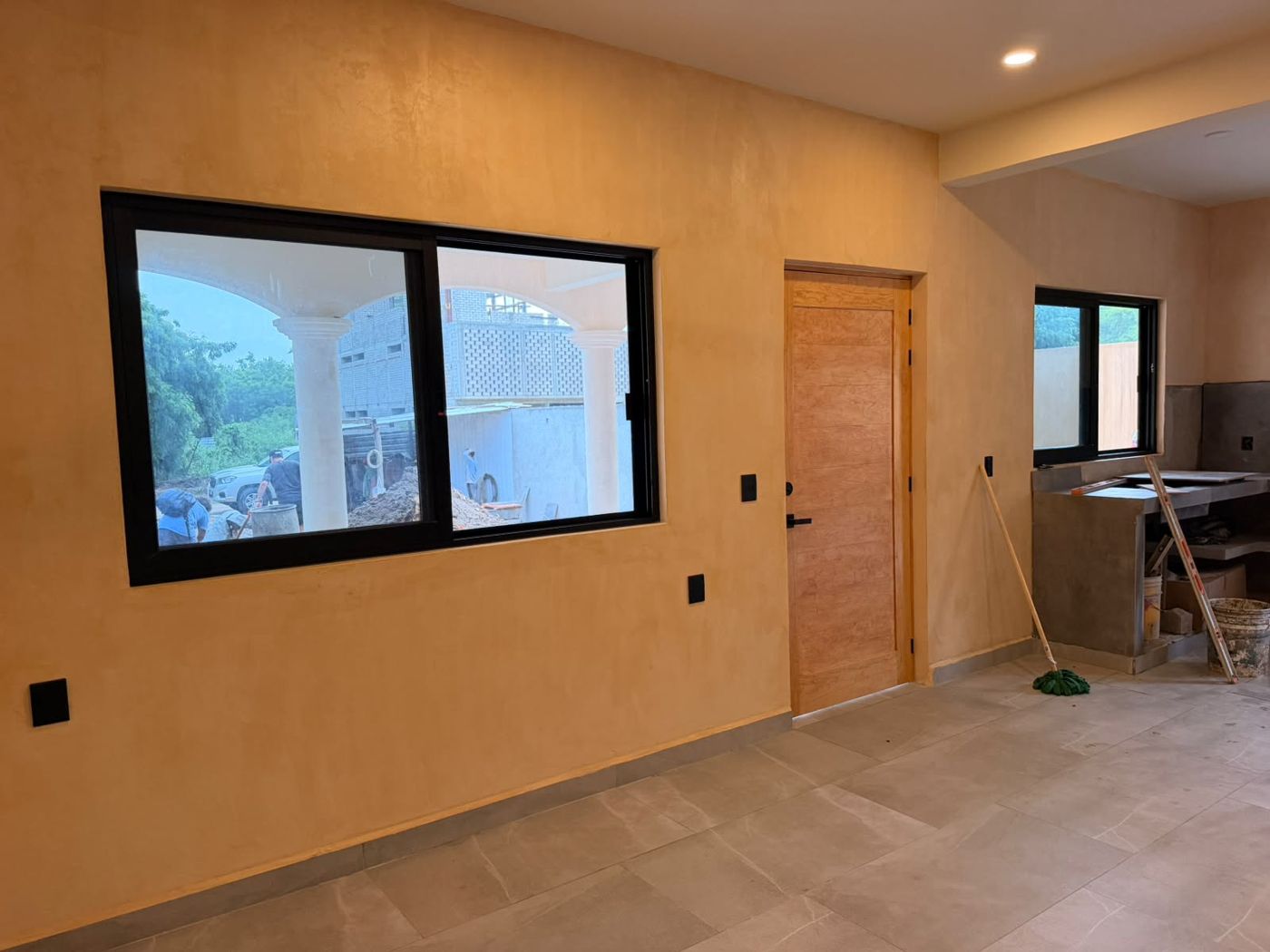 Interior con muro de acabado cálido y puerta de madera