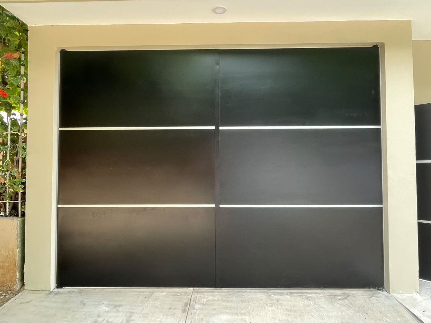 Portón de dos hojas en negro mate con líneas de aluminio