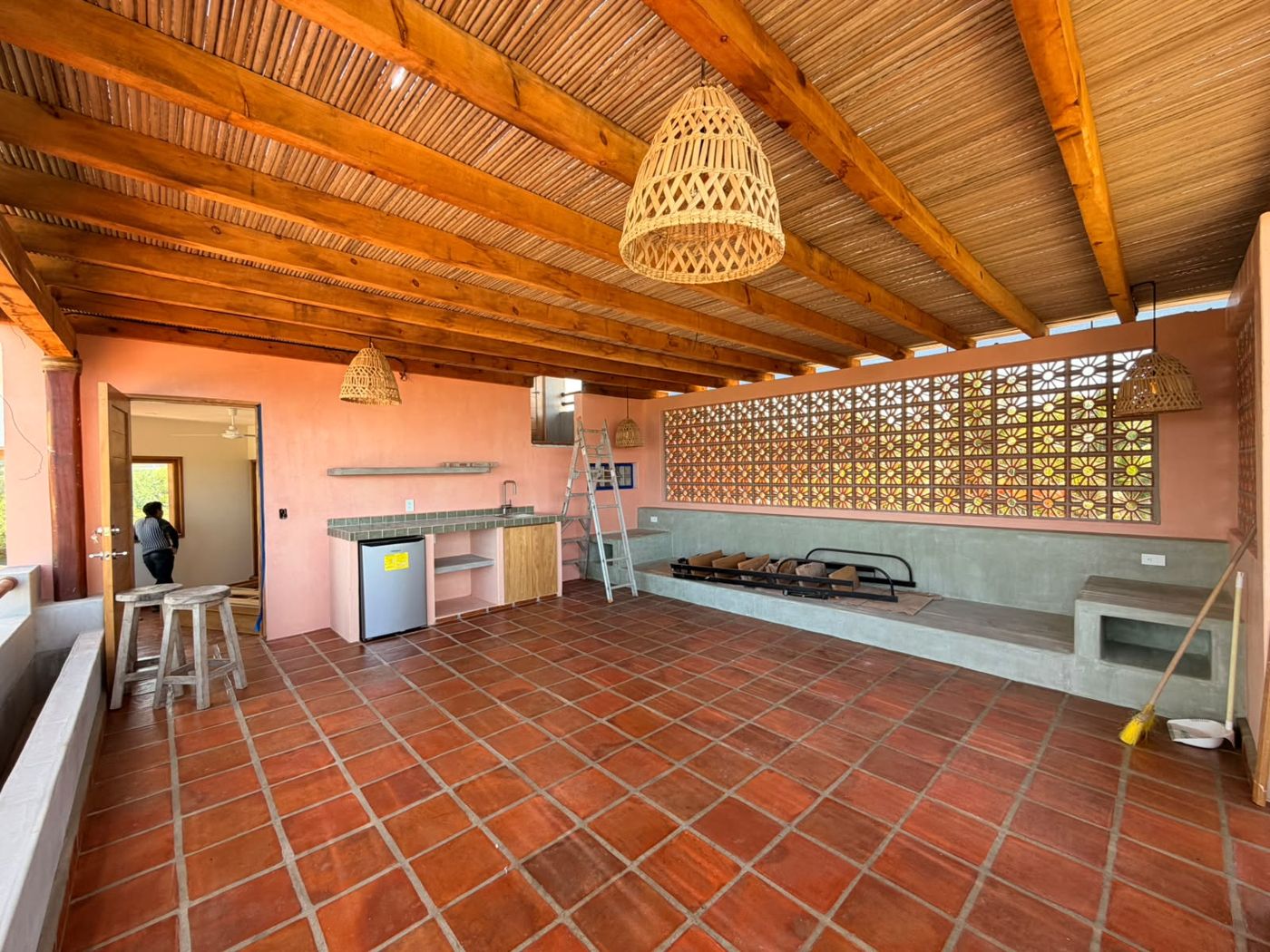 Roof garden con vigas de madera, techo de carrizo, piso de barro y celosía de flor