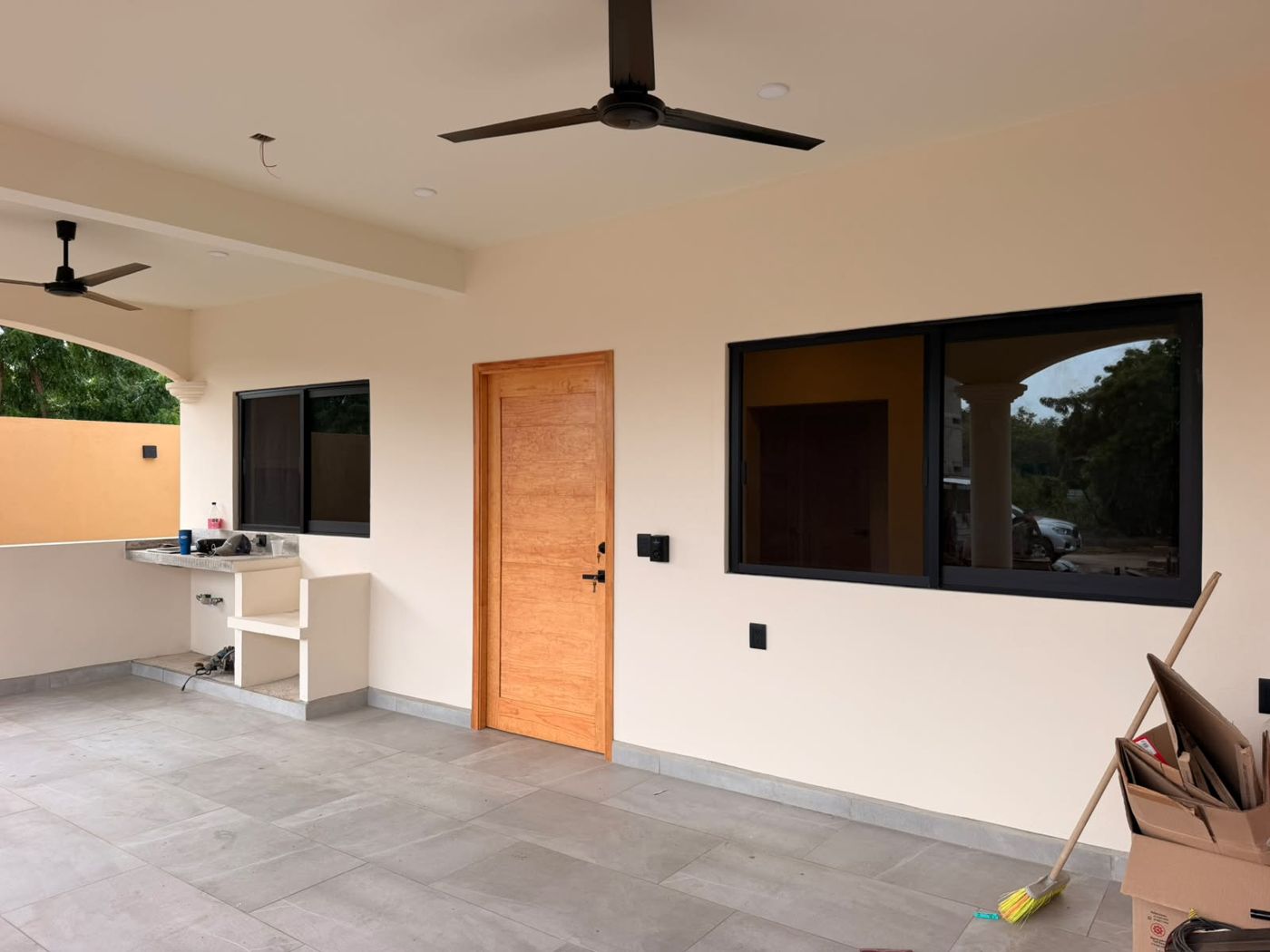 Terraza techada con puerta de madera sólida y ventanas negras